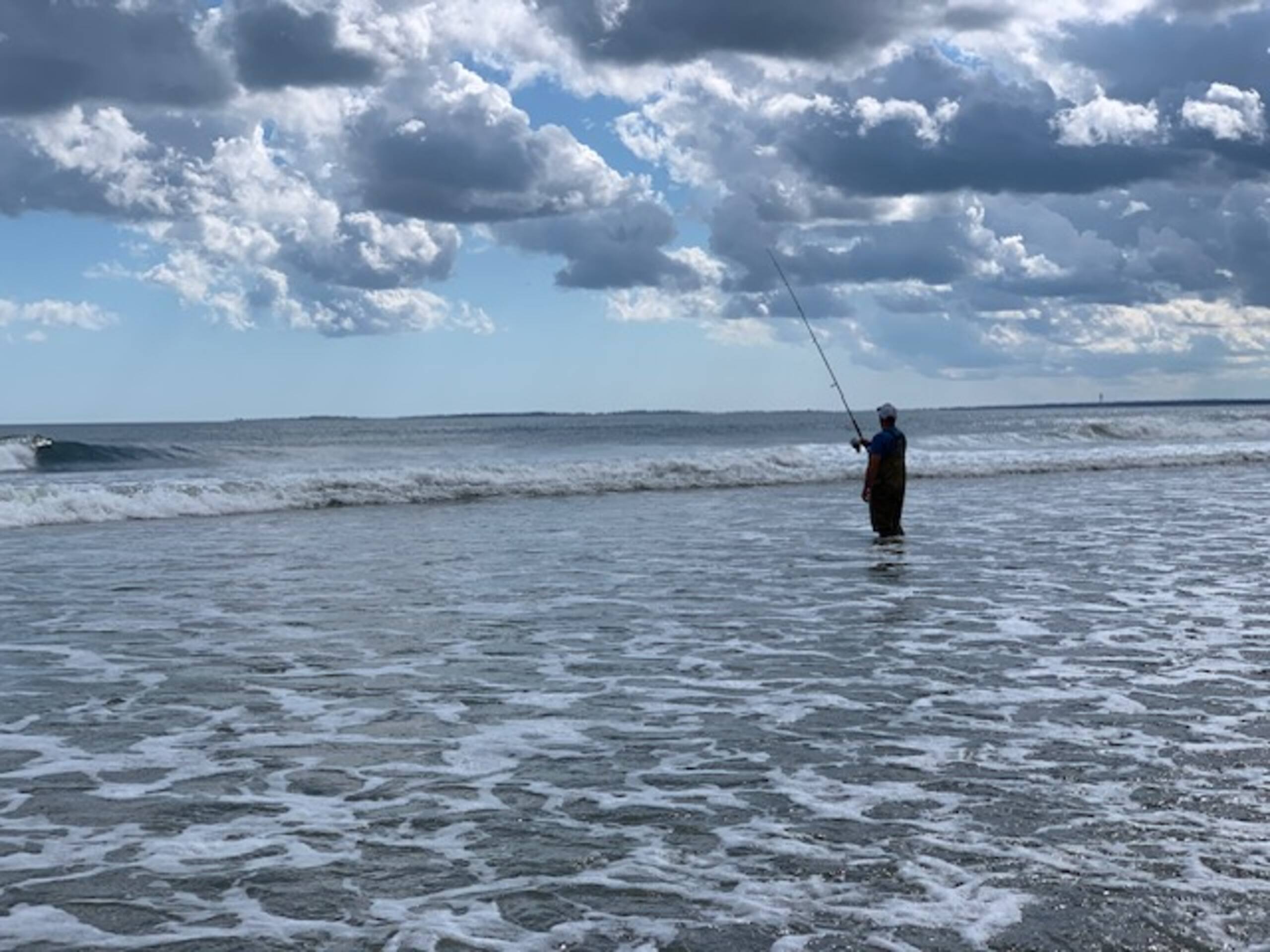Fisherman surf-casting in the ocean