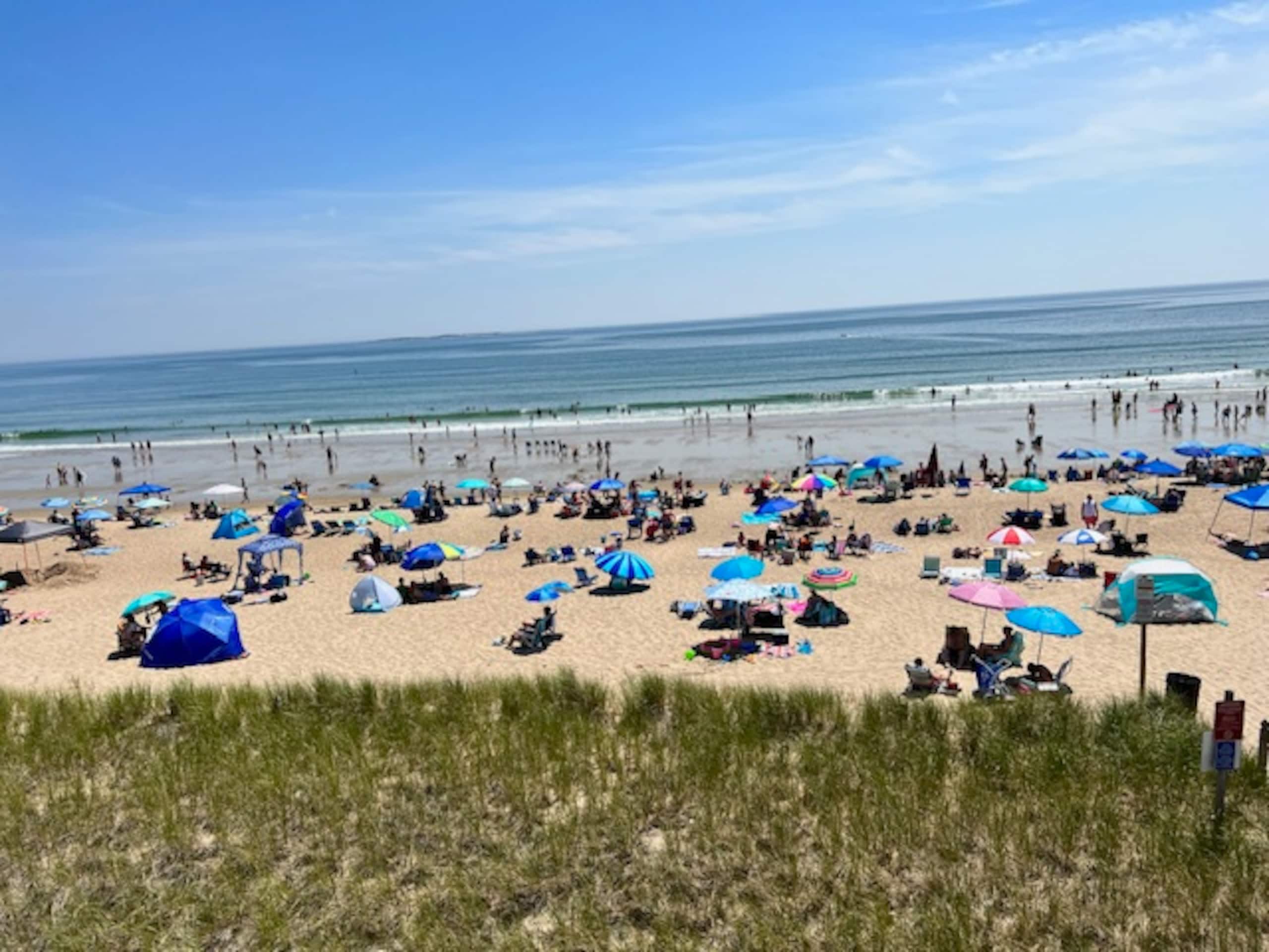 Crowded summer beach day with umbrellas and tents
